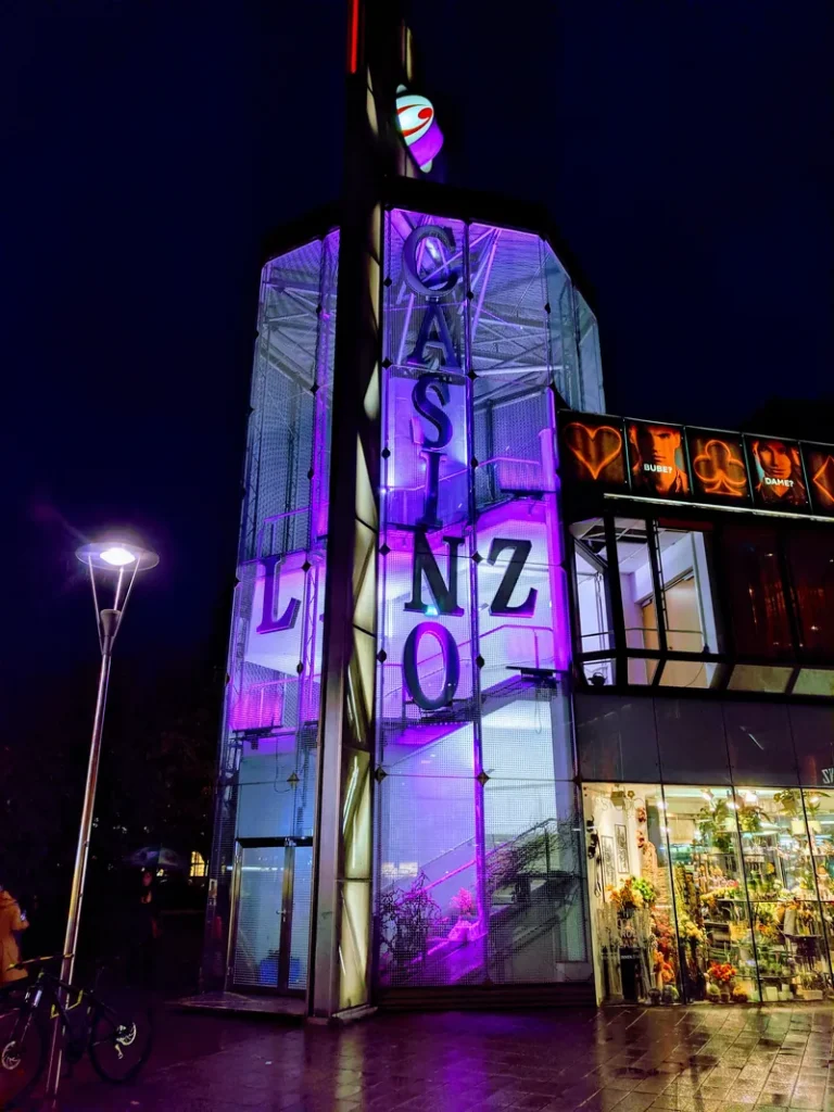Beleuchteter Eingang des Casino Linz bei Nacht